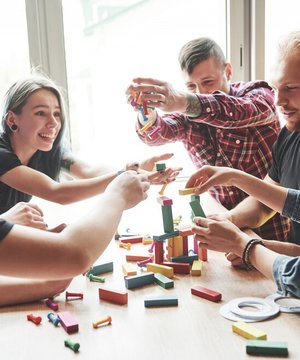 group-creative-friends-sitting-wooden-table-people-were-having-fun-while-playing-board-game_146671-15242