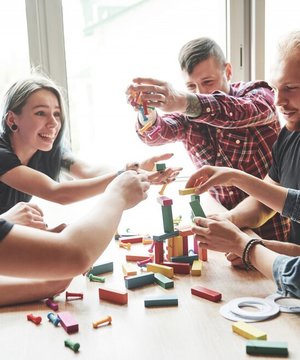 group-creative-friends-sitting-wooden-table-people-were-having-fun-while-playing-board-game_146671-15242