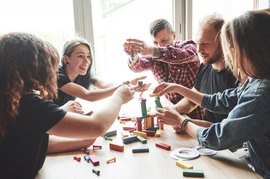 group-creative-friends-sitting-wooden-table-people-were-having-fun-while-playing-board-game_146671-15242